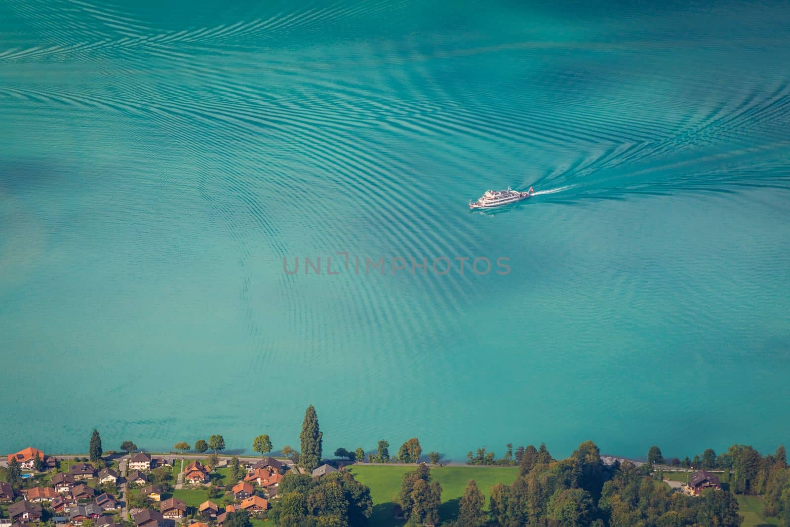 Aerial view of Swiss Alps and Lake Brienz with ferry boat at dramatic sunset, Interlaken, Switzerland
