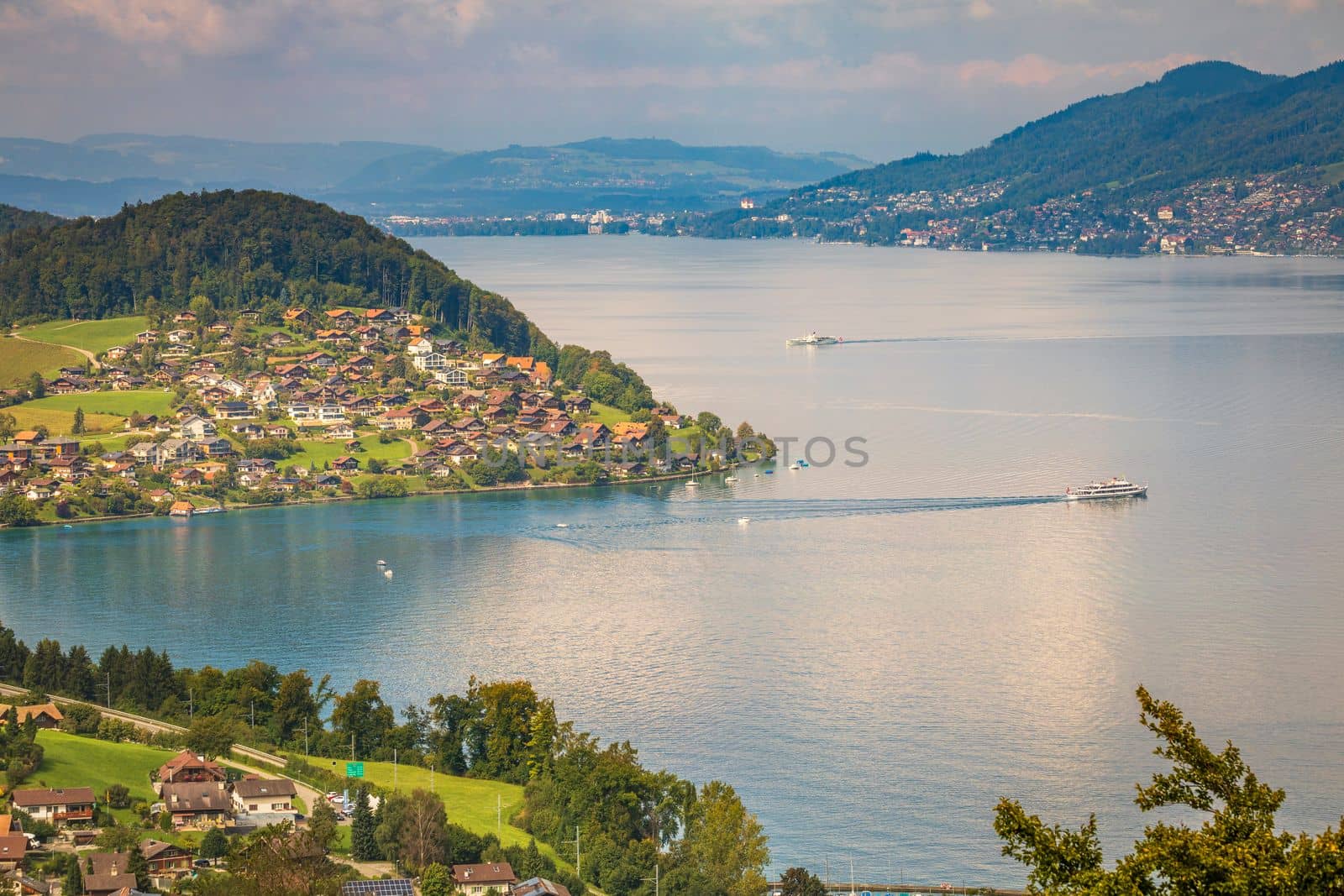 Aerial view of Swiss Alps and Lake Thun with ferry boat at dramatic sunset, Interlaken, Switzerland