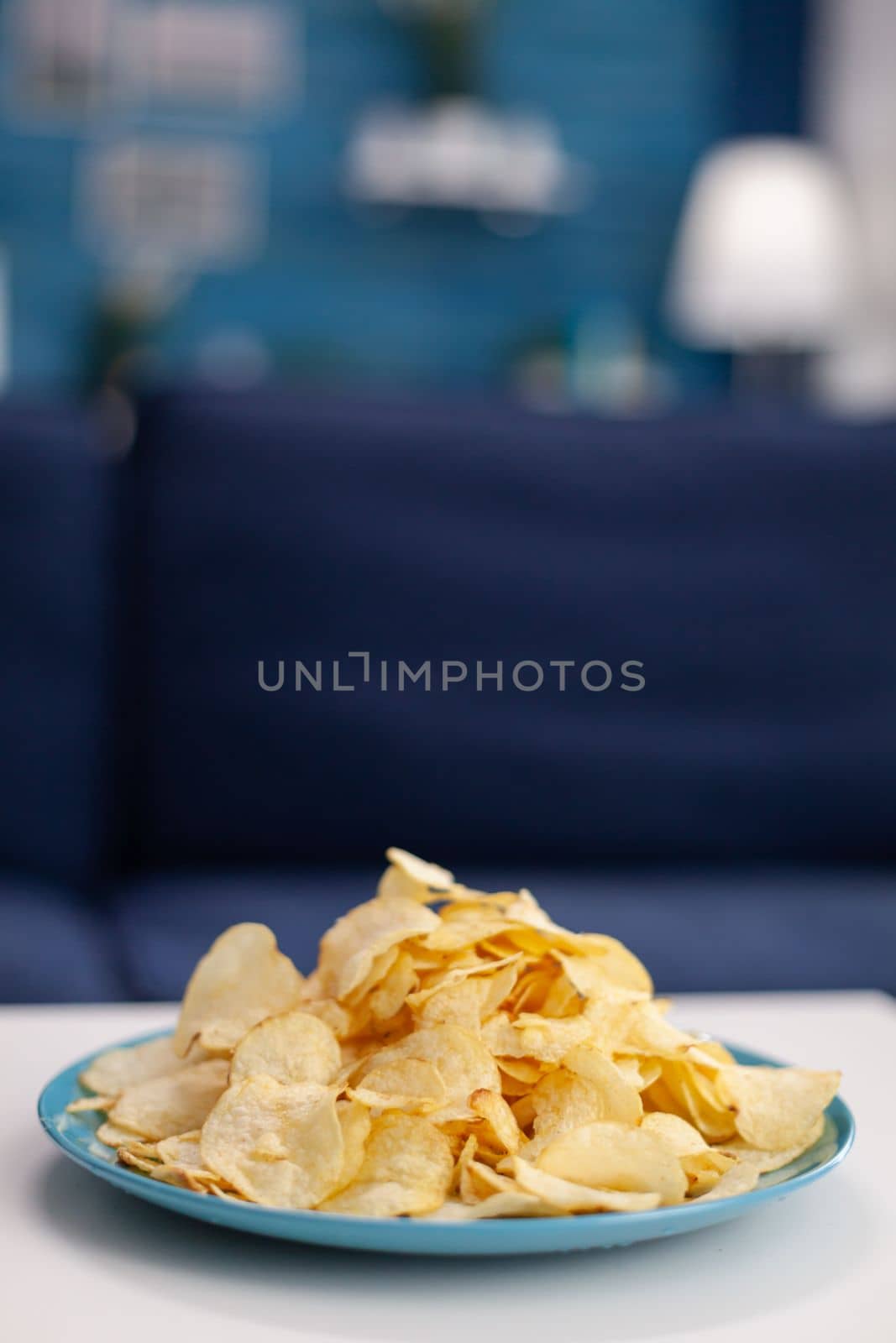 Close up of chips snack on table in empty living room by DCStudio