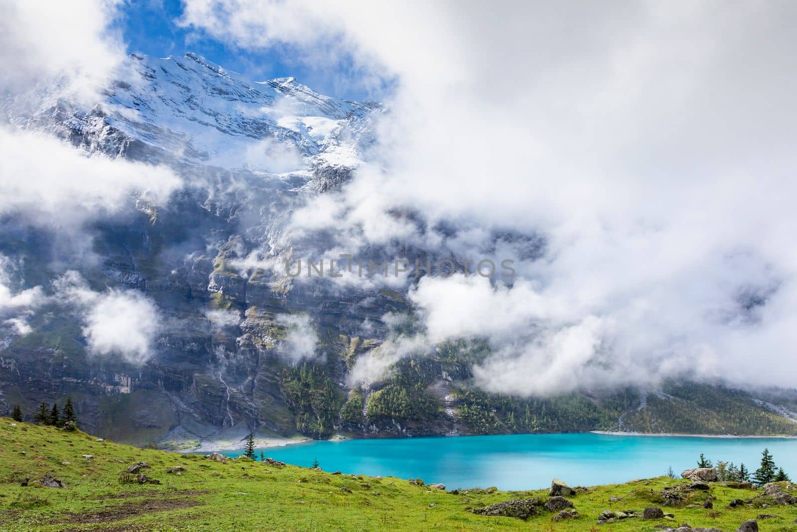 Misty Oeschinensee, Oeschinen lake, on Bernese Oberland swiss alps, Kandersteg, Switzerland