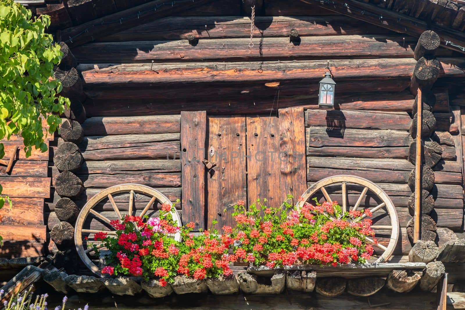 Colorful flowers in rustic balcony at springtime with lamp, Interlaken, Swiss alps