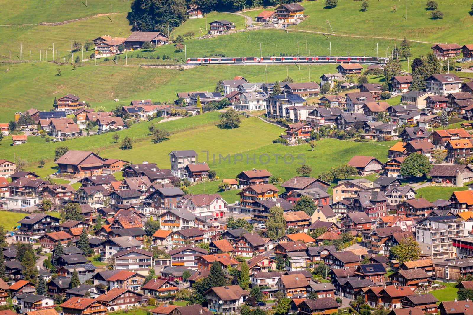 Train and lungern village in the Swiss Alps at sunny day, Switzerland
