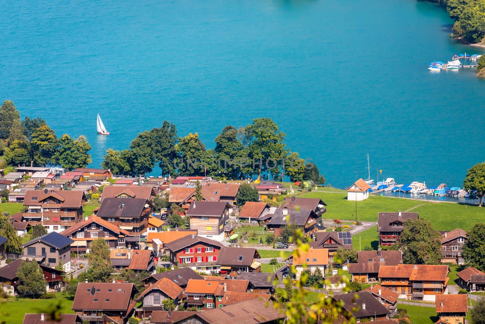 Turquoise Lungernsee and village lungern in the Swiss Alps at sunny day, Switzerland