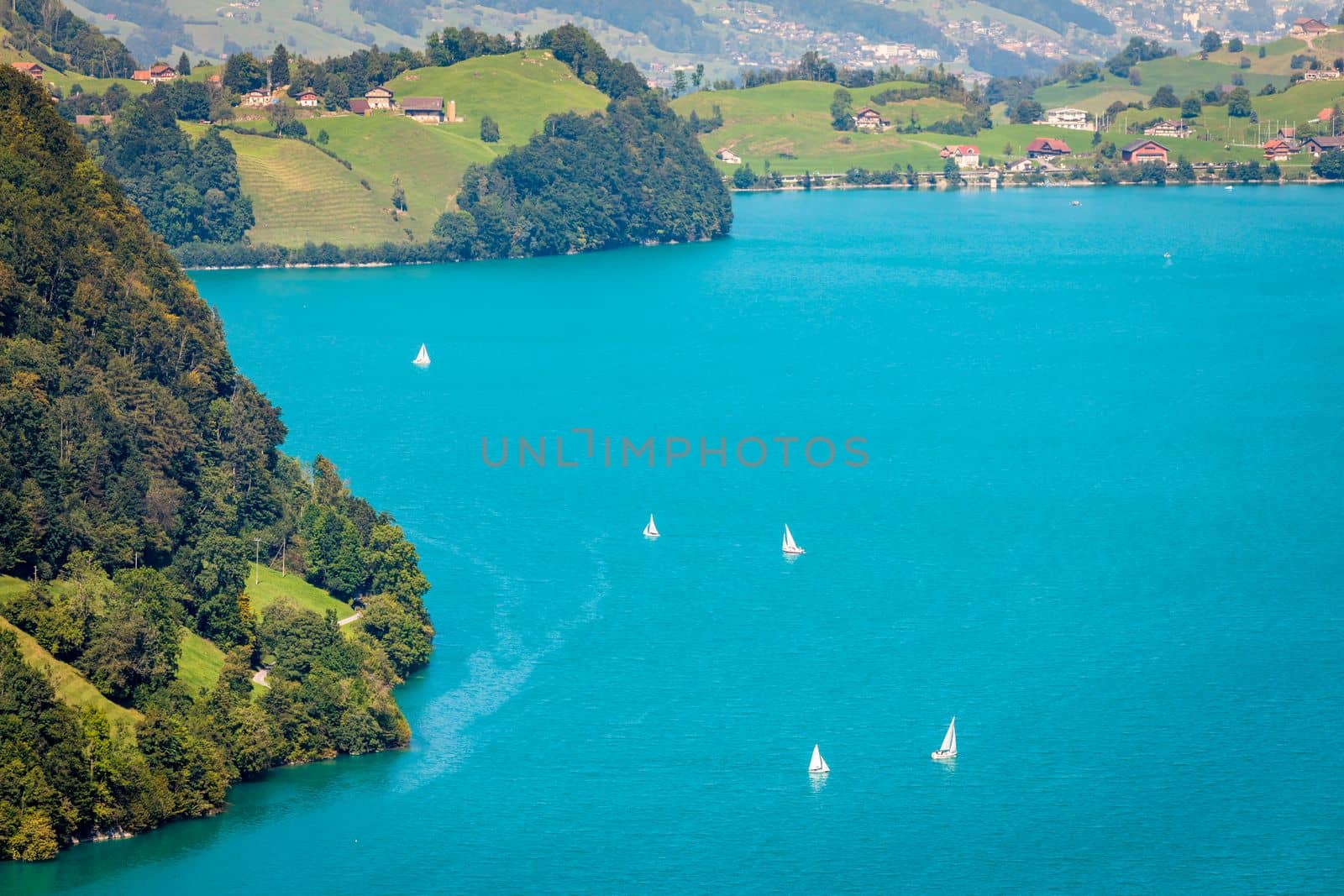 Turquoise Lungernsee and village lungern in the Swiss Alps at sunny day, Switzerland