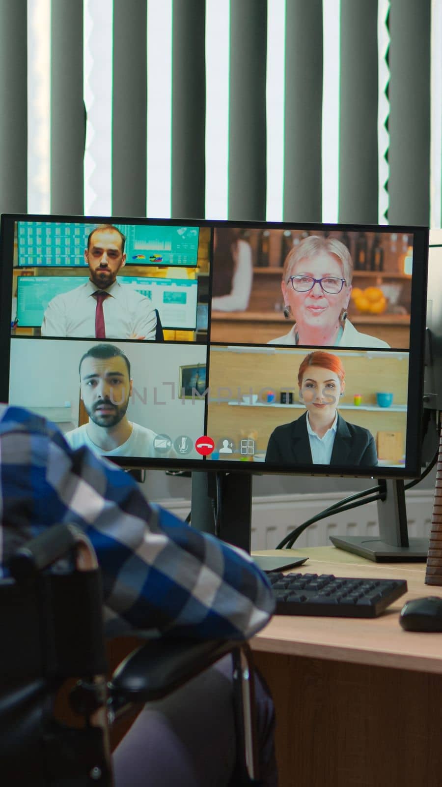 Handicapped disabled manager in wheelchair talking during videocall having online conference in business office. Paralysed, immobilized freelancer working in financial company using modern technology.