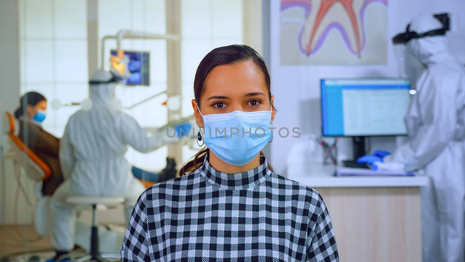 Portrait of woman with mask in dental office looking on camera by DCStudio