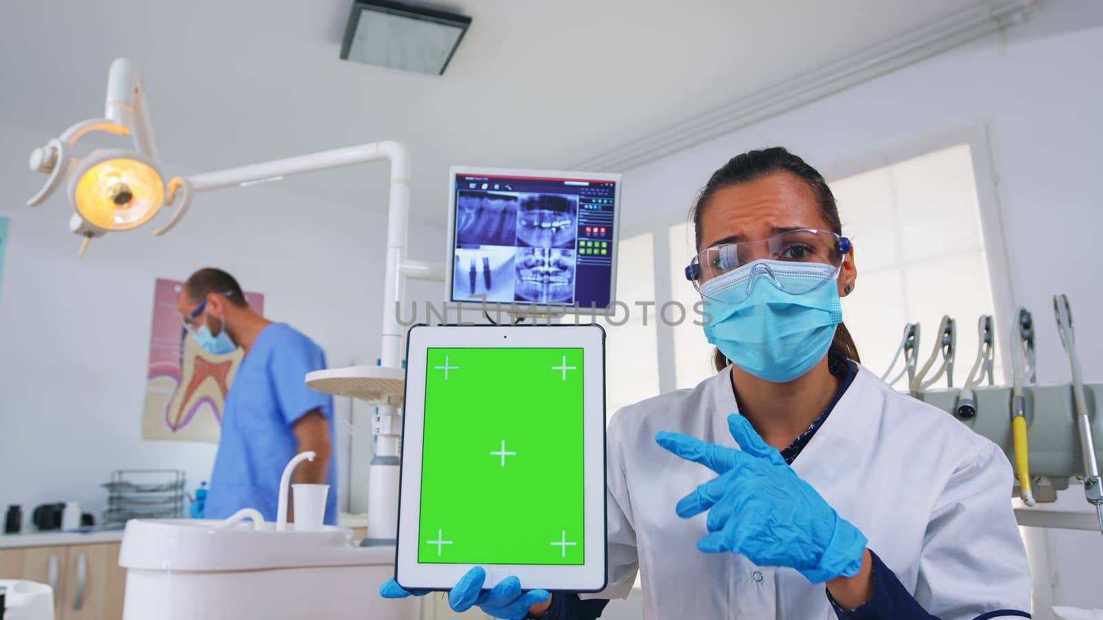 Pov patient to dentist doctor showing tablet with chroma display by DCStudio