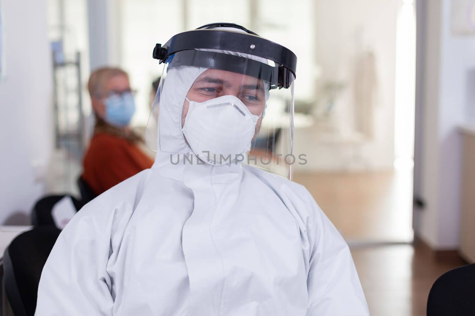 Portrait of tired doctor in dental office looking on camera by DCStudio