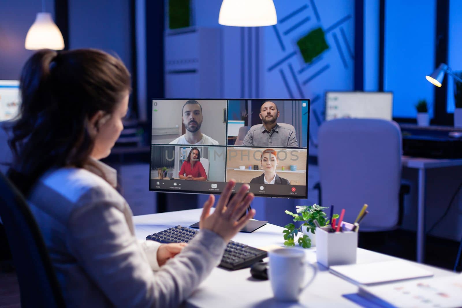 Manager during online video conference with corporate team after midnight using pc in start up business office. Videoconference internet meeting with technology network wireless discussing on video call late at night