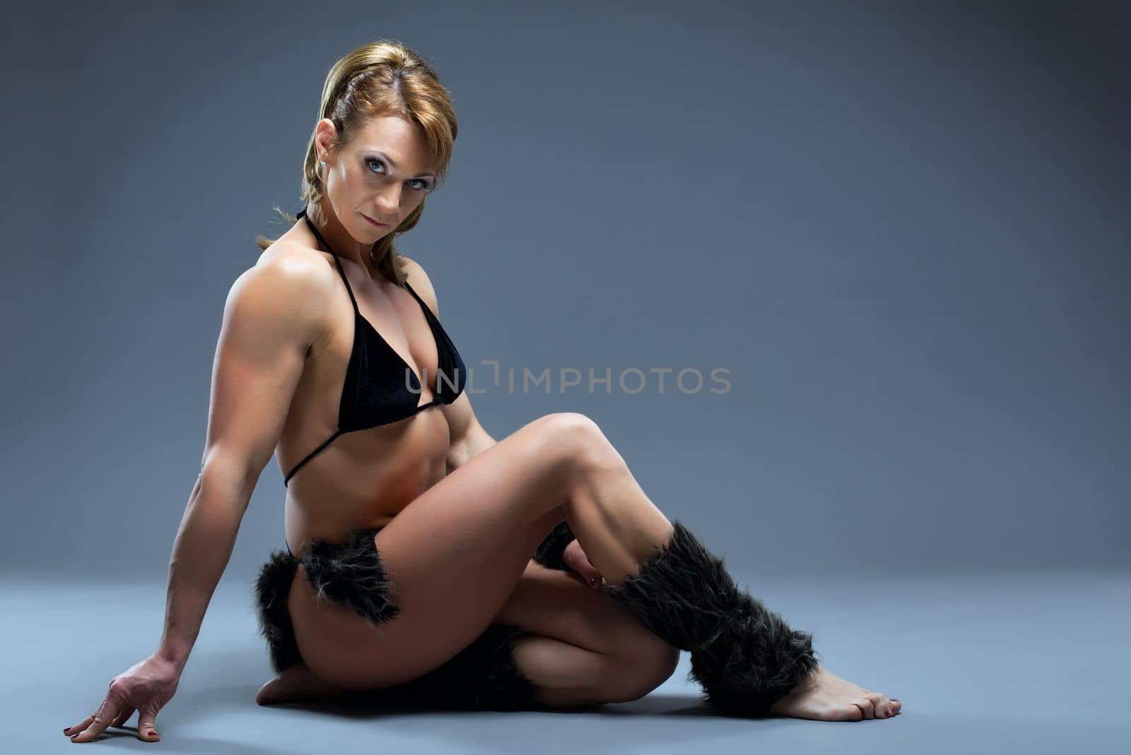 Heavy female body builder posing in amazon fur costume