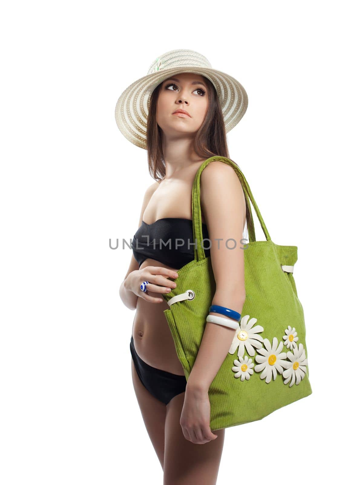 Yong woman posing with beach bag and straw hat isolated