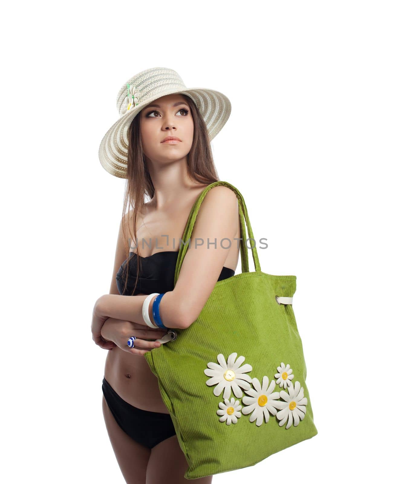 Yong woman posing with beach bag and straw hat isolated
