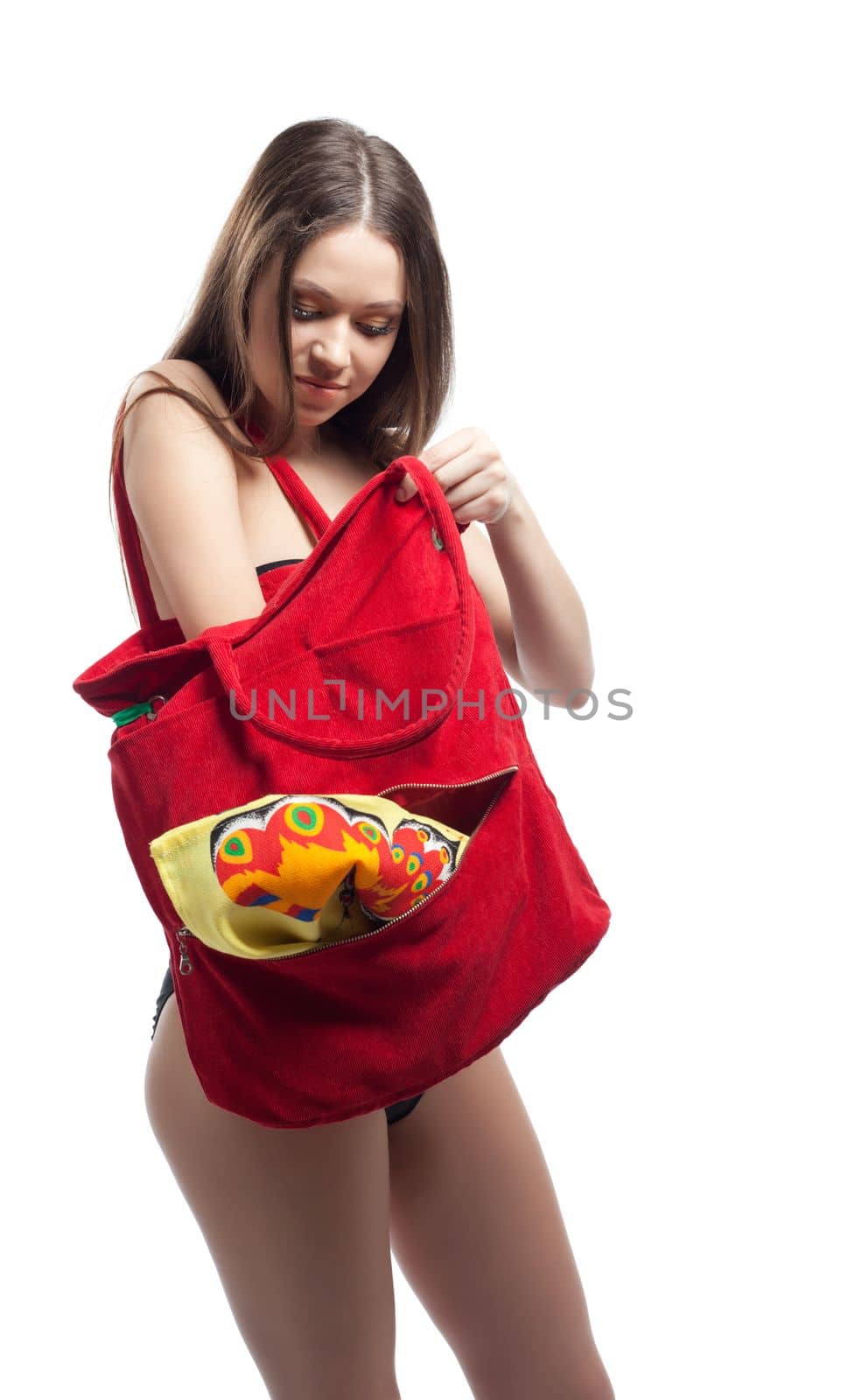 Young woman search towel in red beach bag isolated