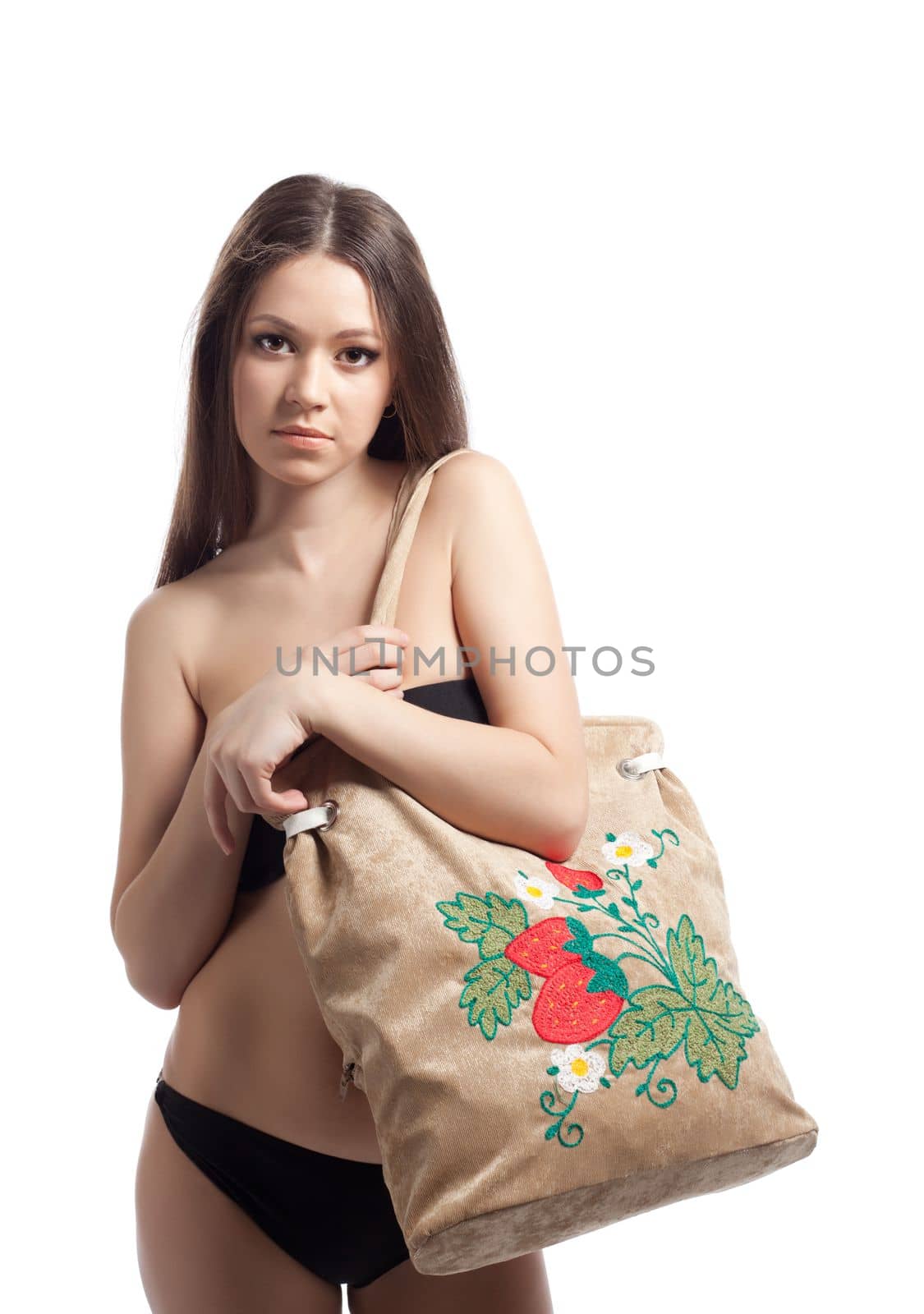 Young woman in black bikini posing with funny beach bag isolated