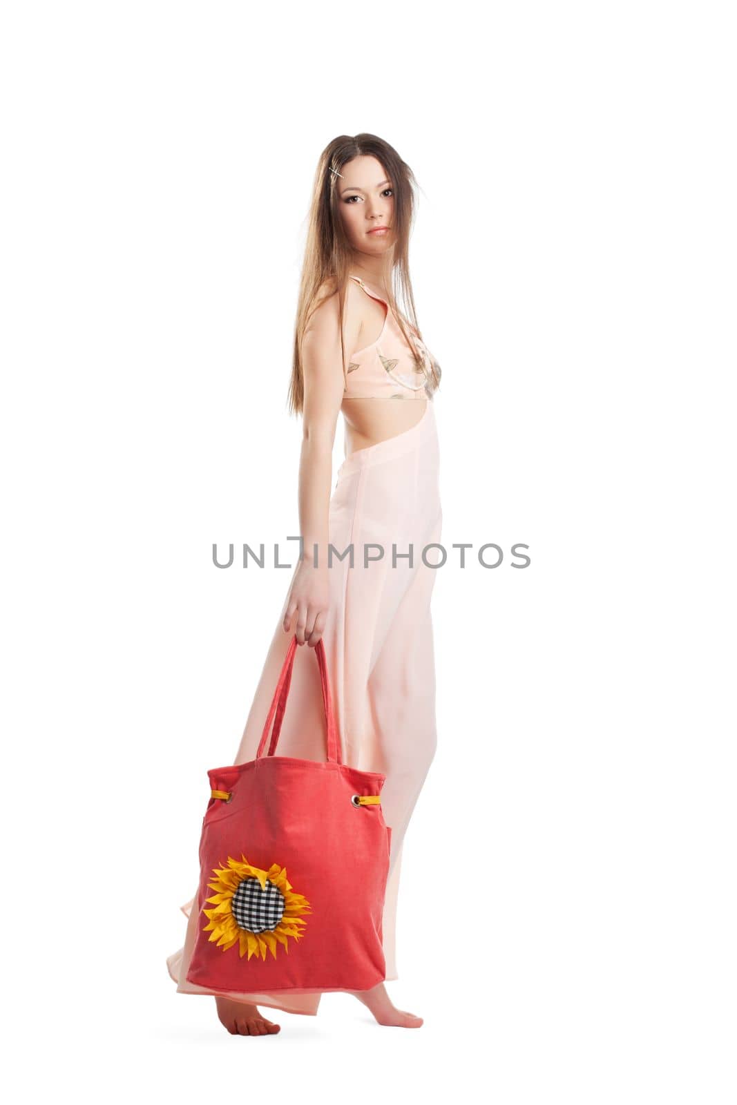 Beauty girl with long hair walk in rose dress and red beach bag isolated