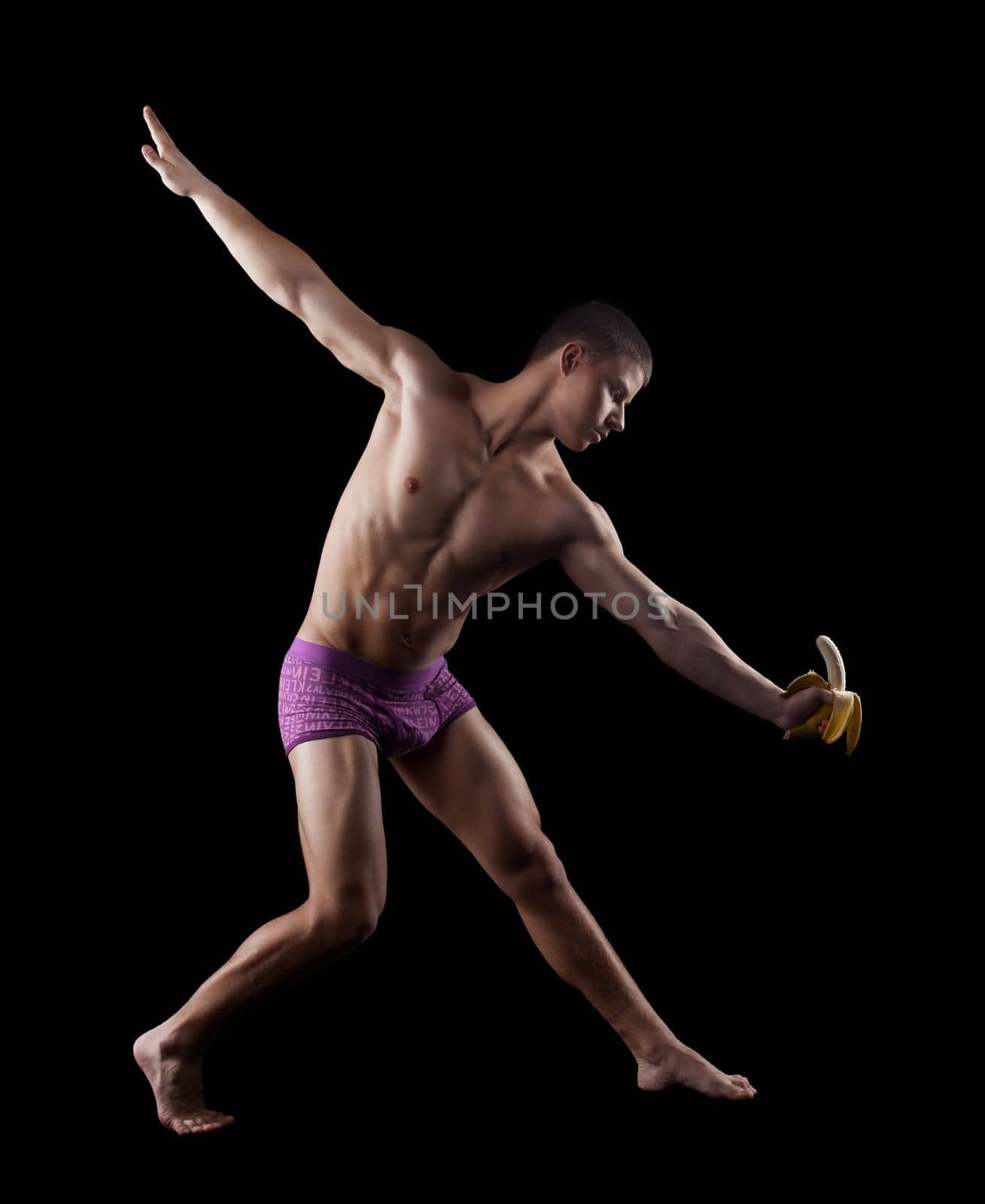 nude athletic man dance striptease with banana in dark