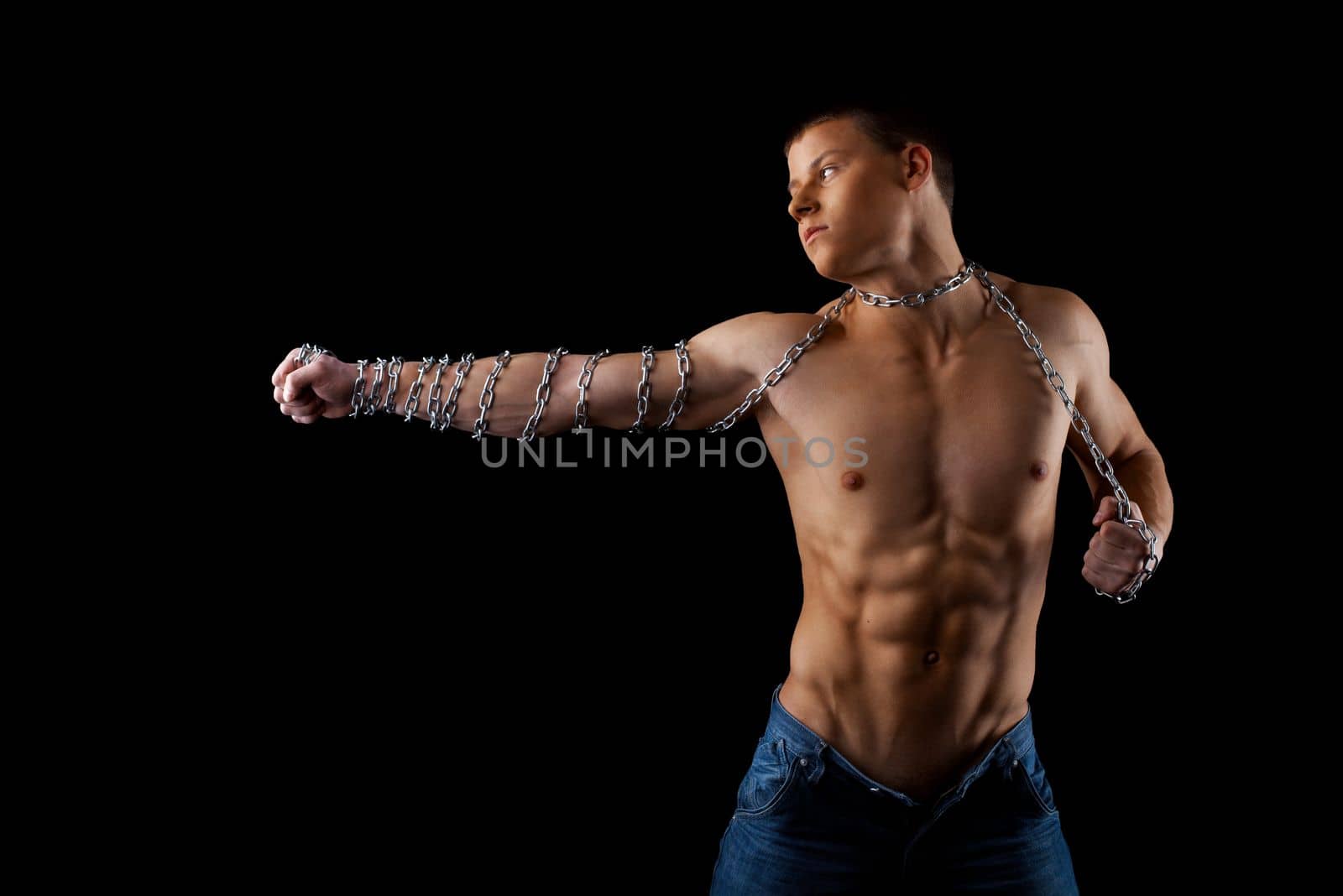 aggressive athletic man with chain on hands fight on light