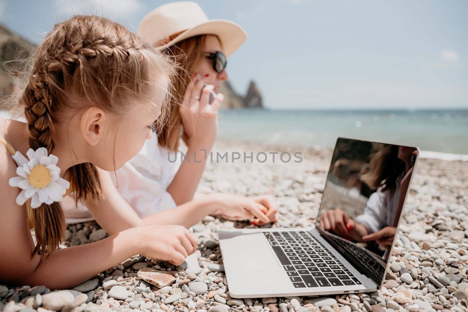 Woman sea laptop. Business woman with daughter, working on lapto by panophotograph