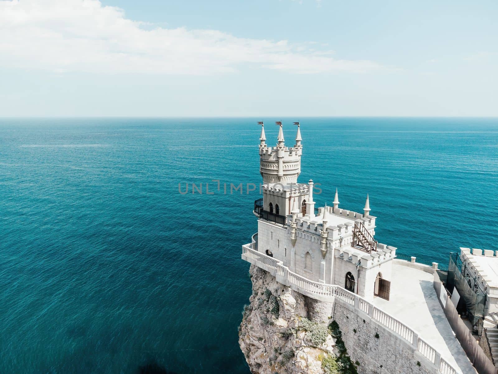 Aerial view of Swallow's Nest castle on the rock in Black Sea. It is a symbol and landmark of Crimea. Beautiful scenic panorama of the Crimea coast. Amazing Swallow's Nest at the precipice.