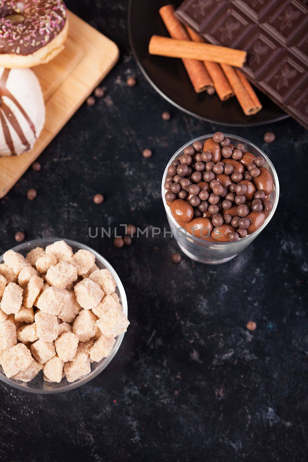 Chocolate tablet next to other candies by DCStudio