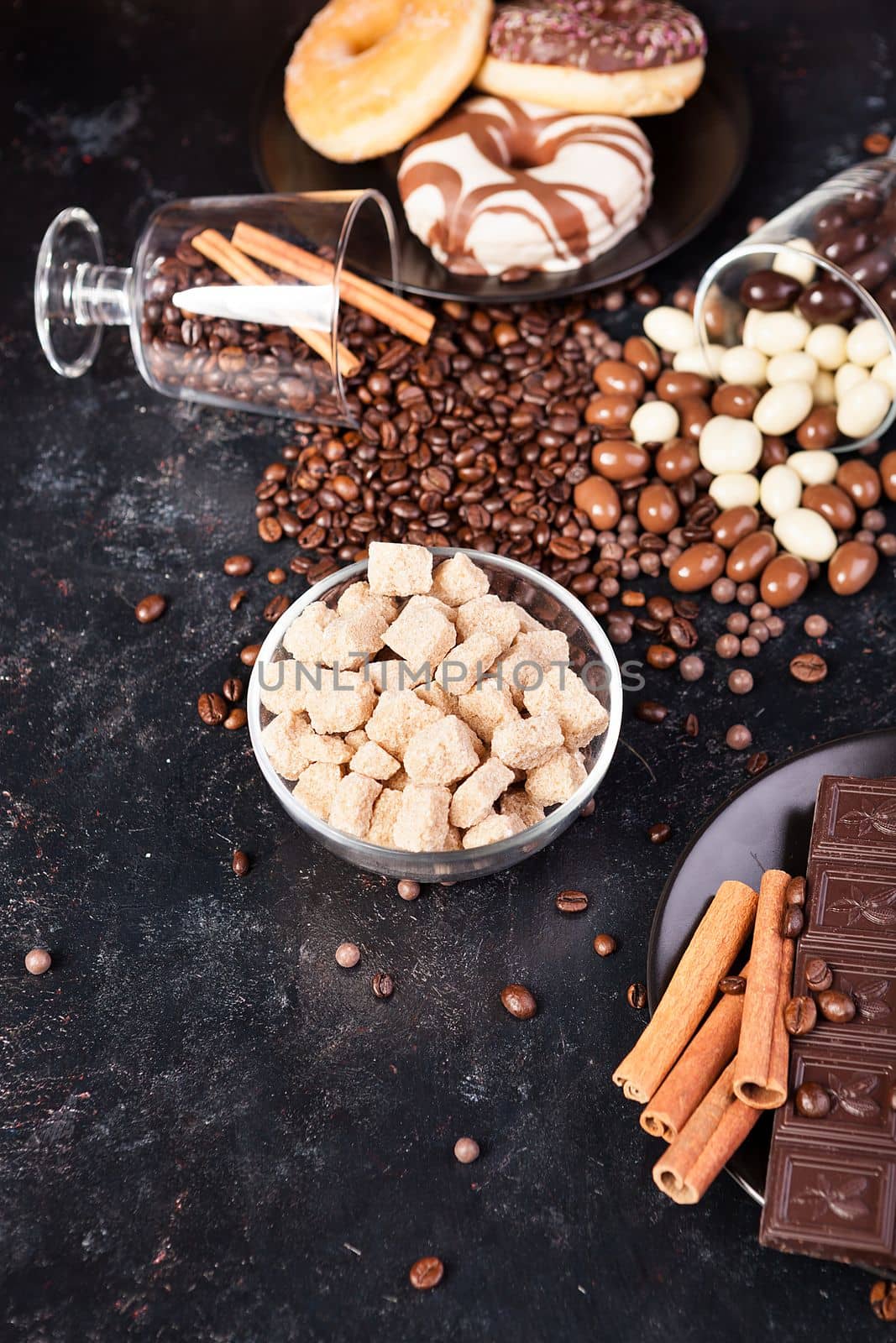 Brown sugar in a glass bowl next to candies and sweets by DCStudio