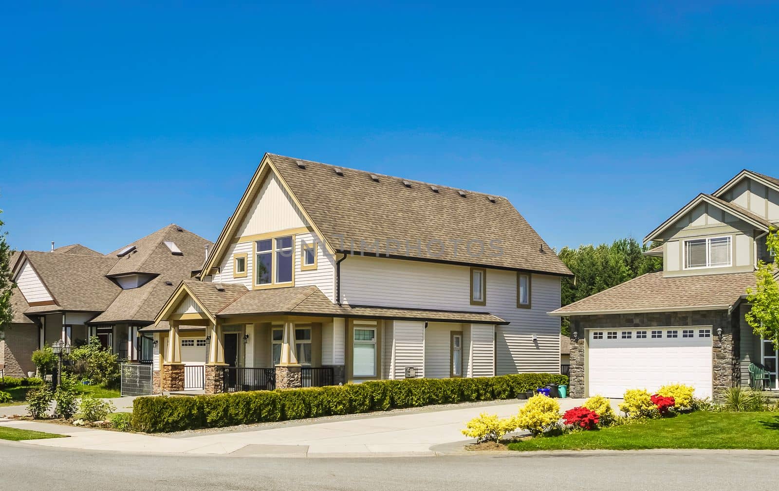 A perfect neighborhood. Big family house with concrete driveway to double size garage. Residential house with door steps to the entrance under the porch