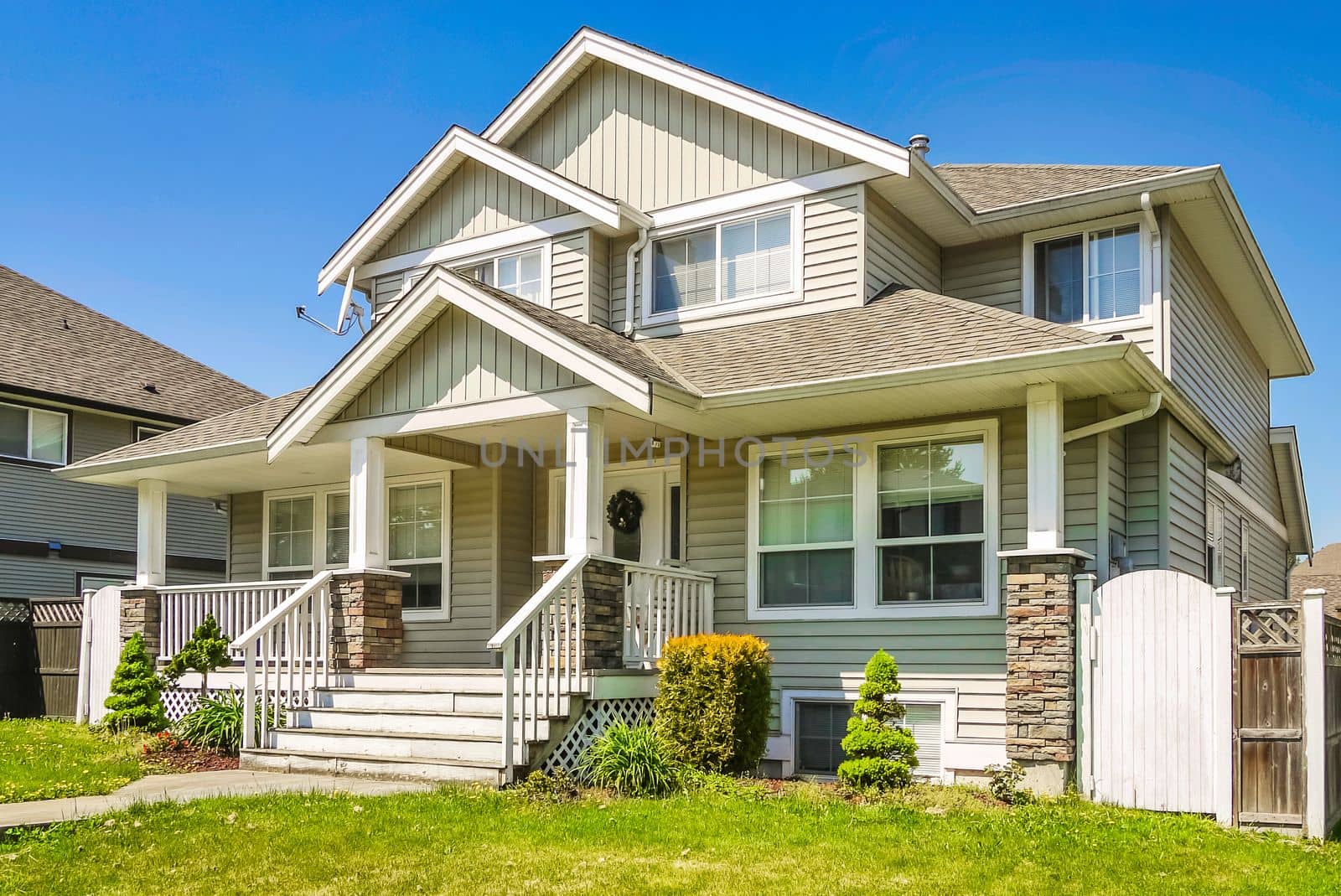 A perfect neighborhood. Luxury residential house with concrete pathway over front yard. Residential house with door steps at the entrance