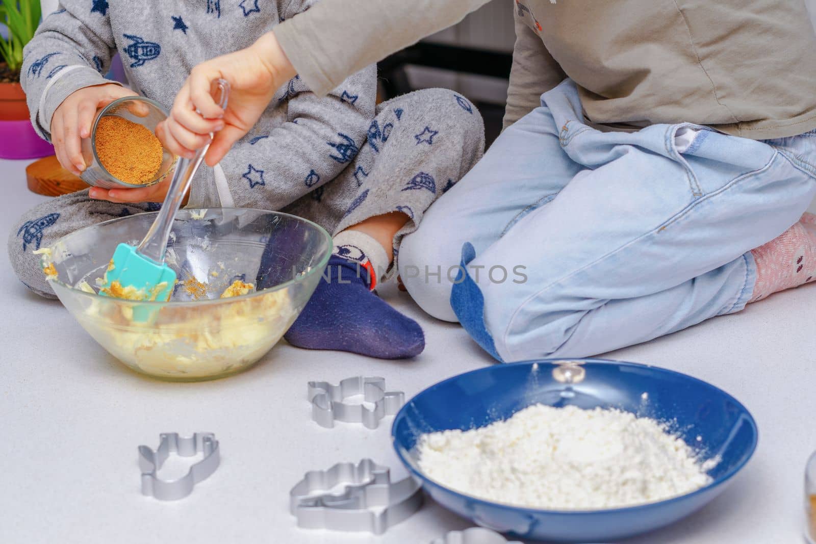 glass jar with brown sugar and a spoon in the background the hands of a woman preparing a cake