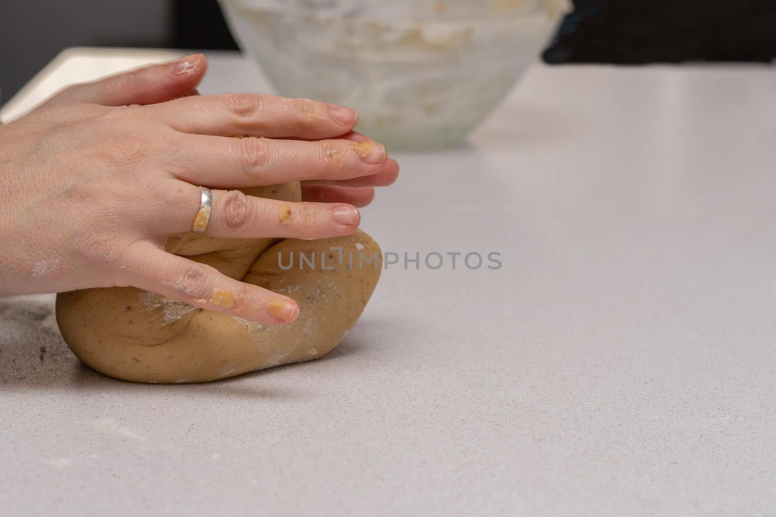glass jar with brown sugar and a spoon in the background the hands of a woman preparing a cake