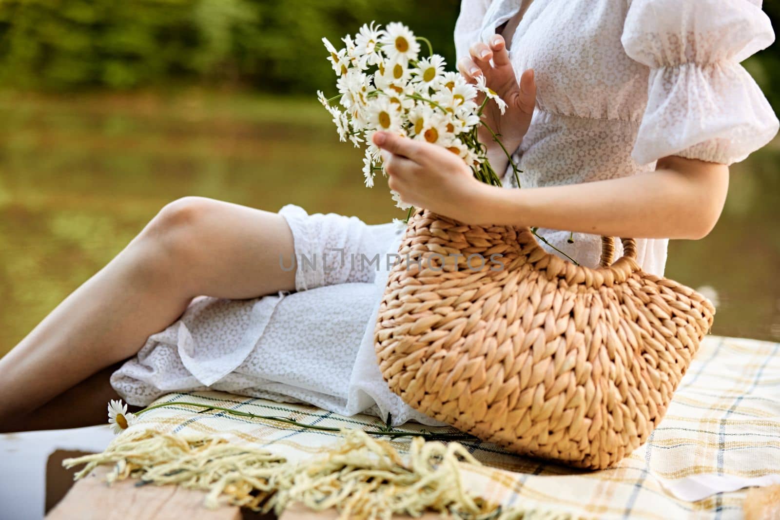 photos of a woman without a face sitting on a pier by the lake with a wicker bag by Vichizh