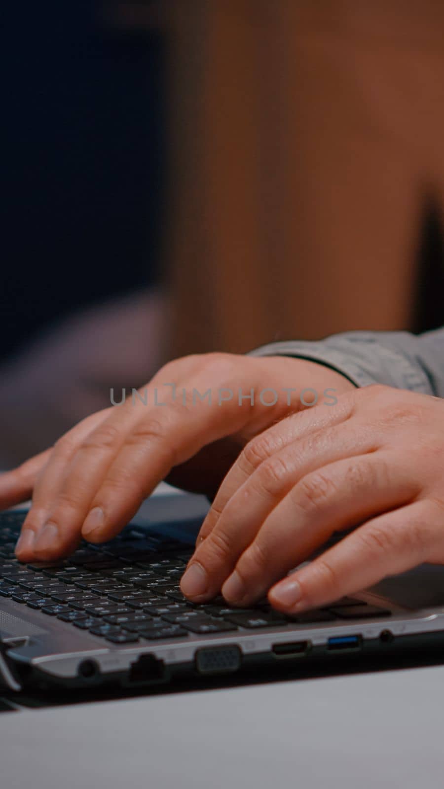 Close-up of businessman hands on keyboard sitting at desk table in startup company office browsing economic ideas on internet. Entrepreneur typing financial statistics answering business email