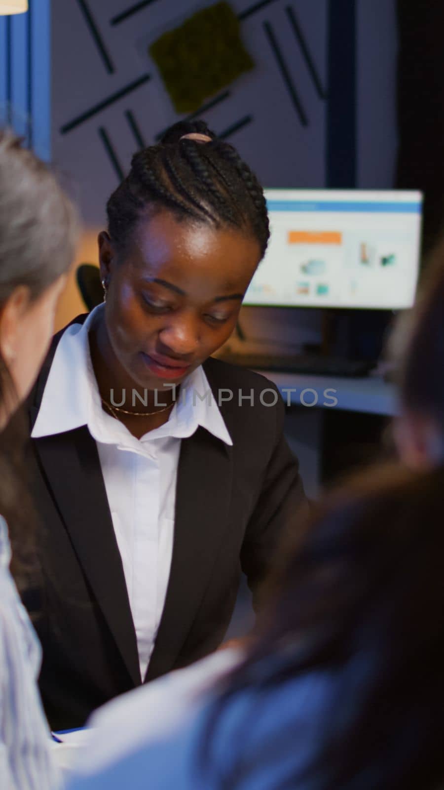 Black african american manager brainstorming company ideas checking management presentation paperwork working overtime in meeting room in evening. Diverse multi ethnic teamwork solving corporate ideas