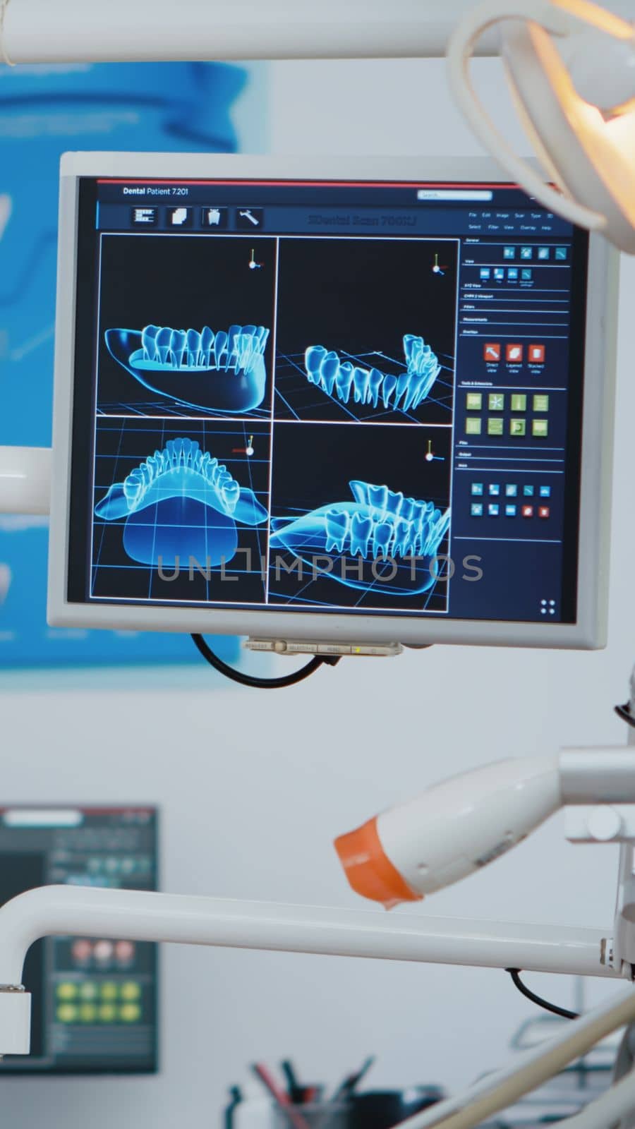 Close up revealing shot of medical stomatology display with x ray images on it. Empty professional hospital stomatology chair with nobody in it. Modern dentist equipment with dentistry tools