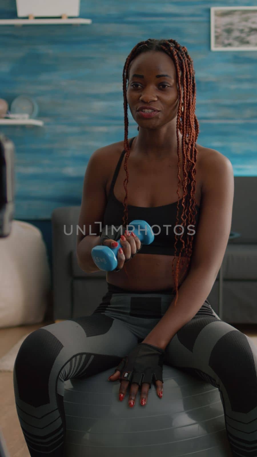 Athletic woman trainer stretching body muscles recording morning yoga workout by DCStudio