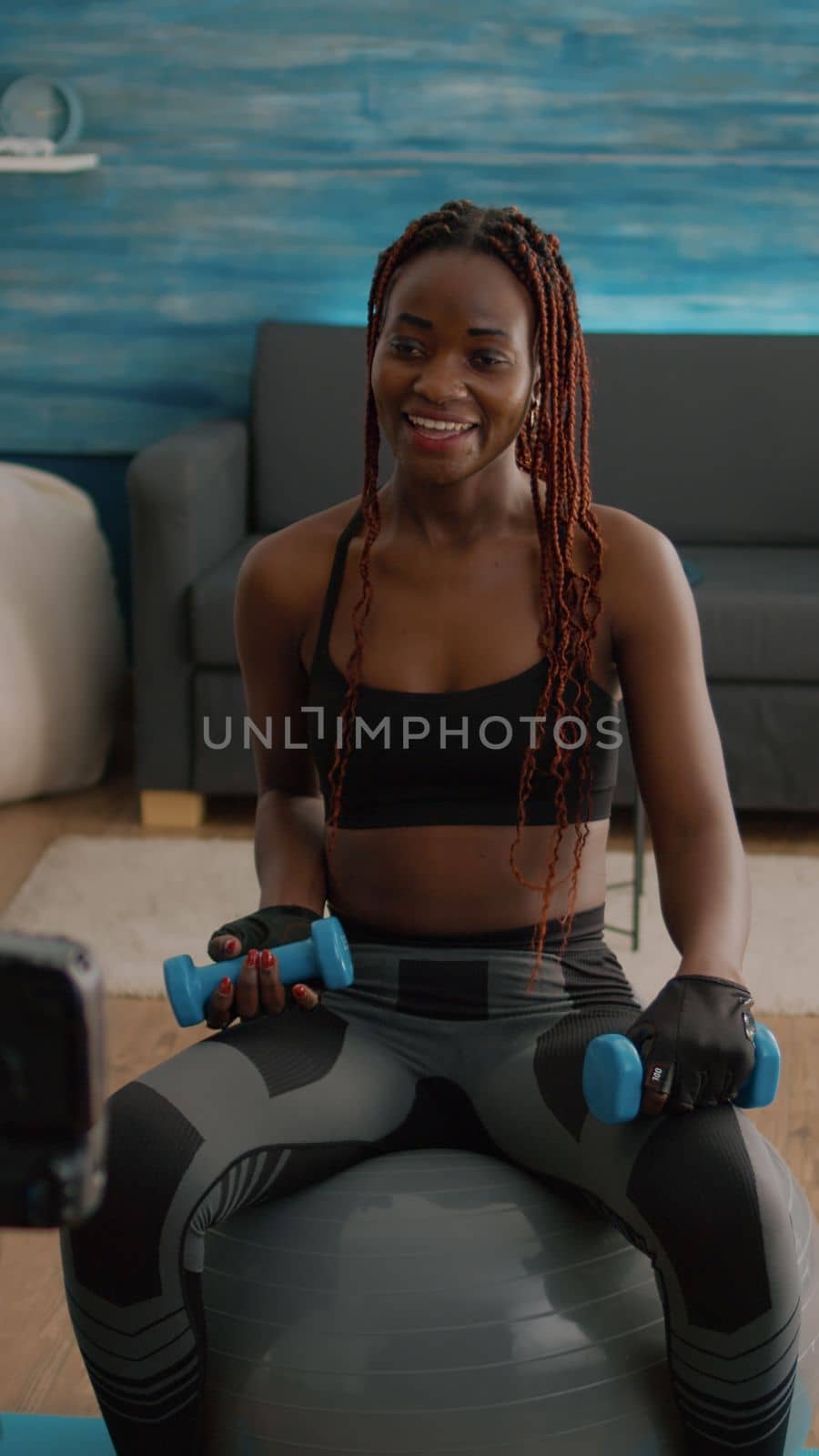 Black woman trainer practicing morning yoga exercise sitting on fitness swiss ball by DCStudio