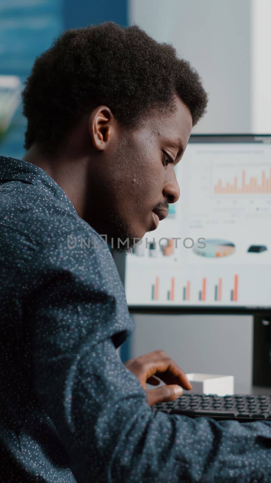 Selective focus on black american guy working from home, taking notes on paper notepad by DCStudio