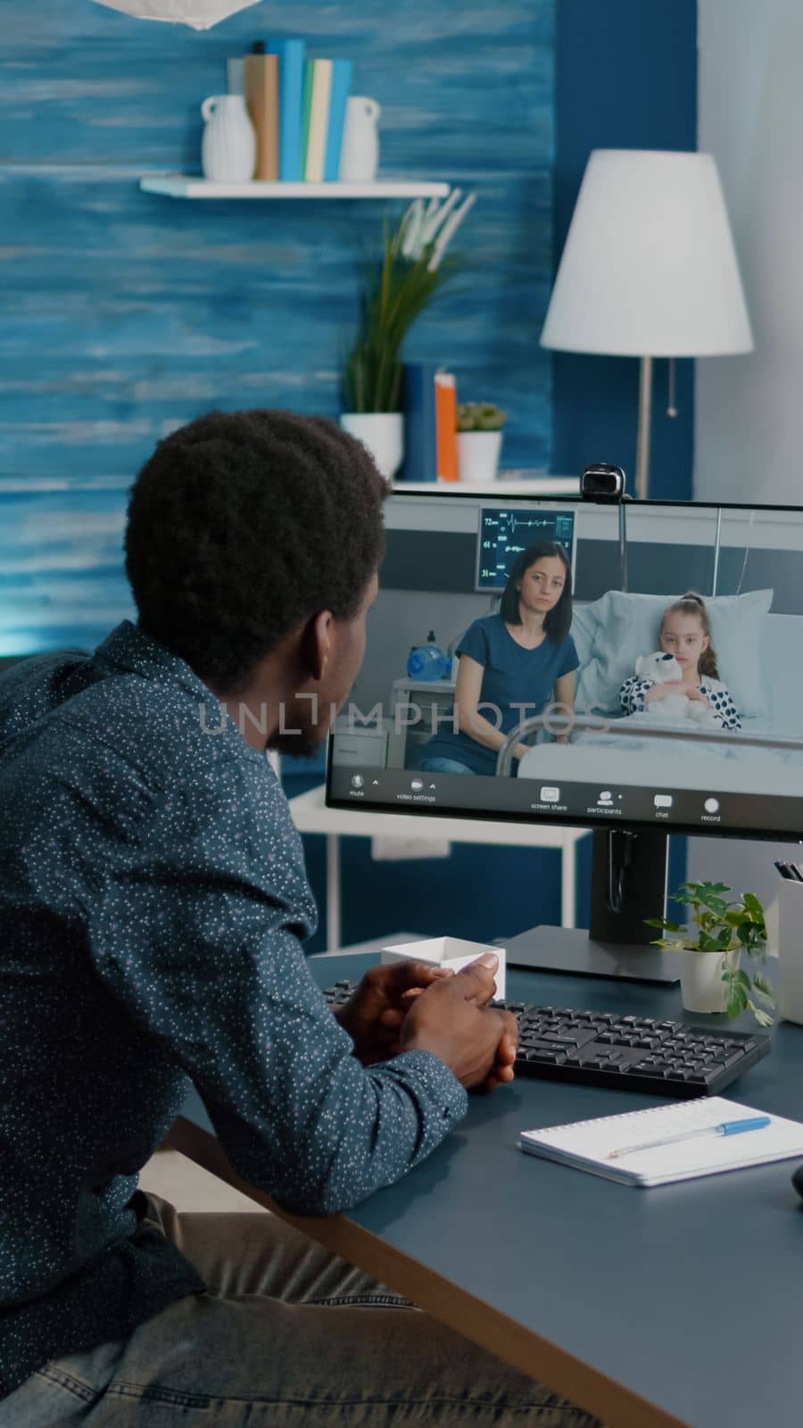 Black man talking with his family who is in hospital ward, using intenet web online teleconference video call to connect with loved ones. Webcam app remote screen healthcare consultation