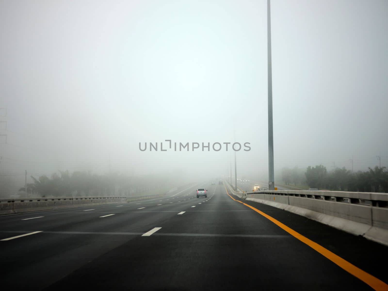 Road in the fog, sign mention keep distance for Motorway-t7.svg by Hepjam