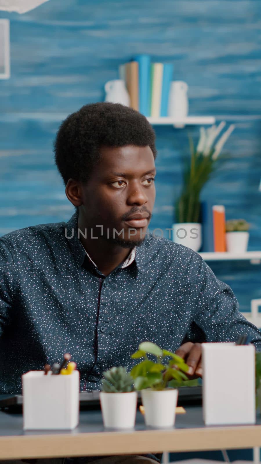 Authentic african american man computer user working from home in modern flat, remote black guy worker typing on computer, freelancer using internet from office. Online communication, lifestyle and social media browsing