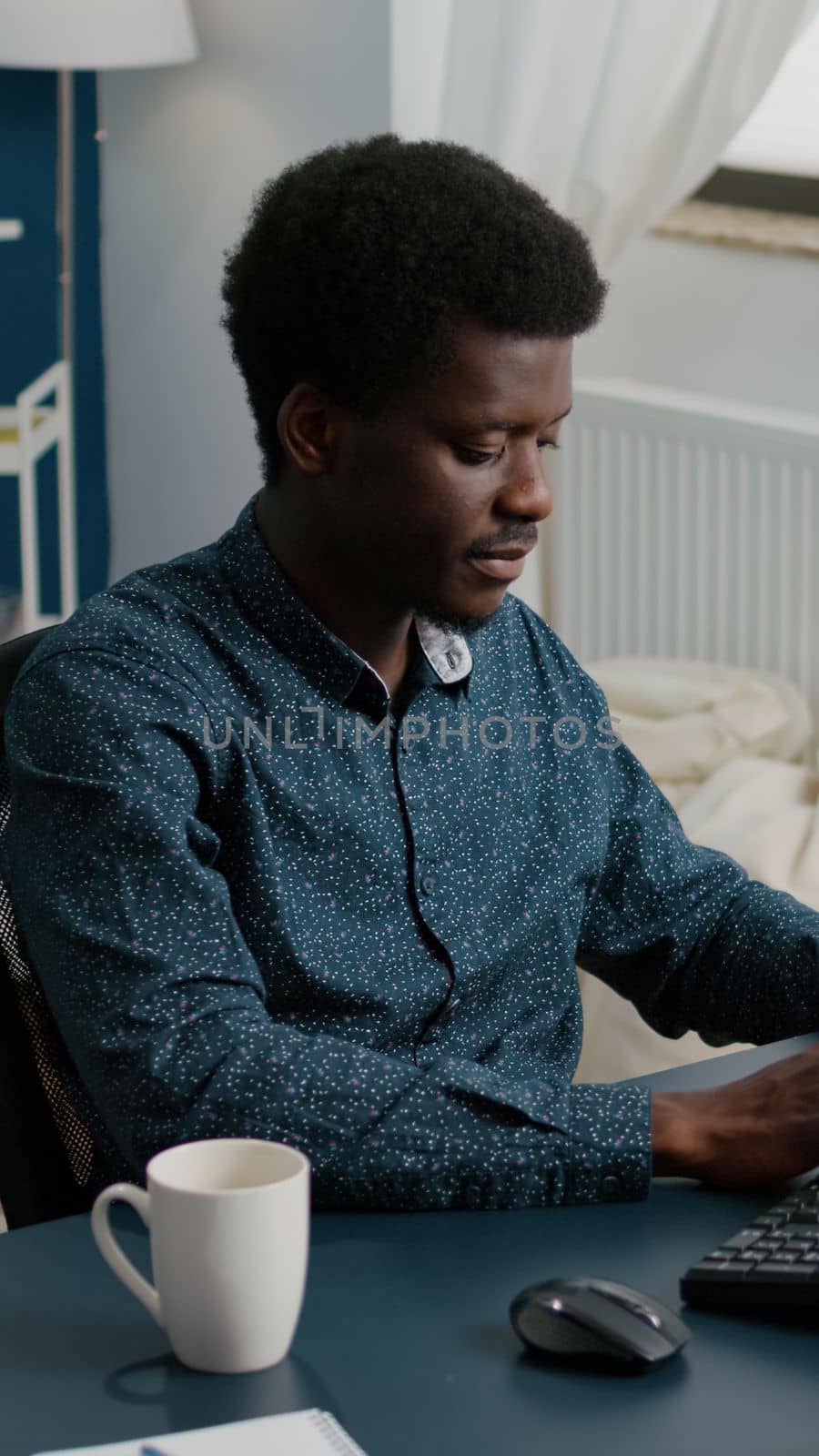 Authentic smiling black african american man working from home by DCStudio
