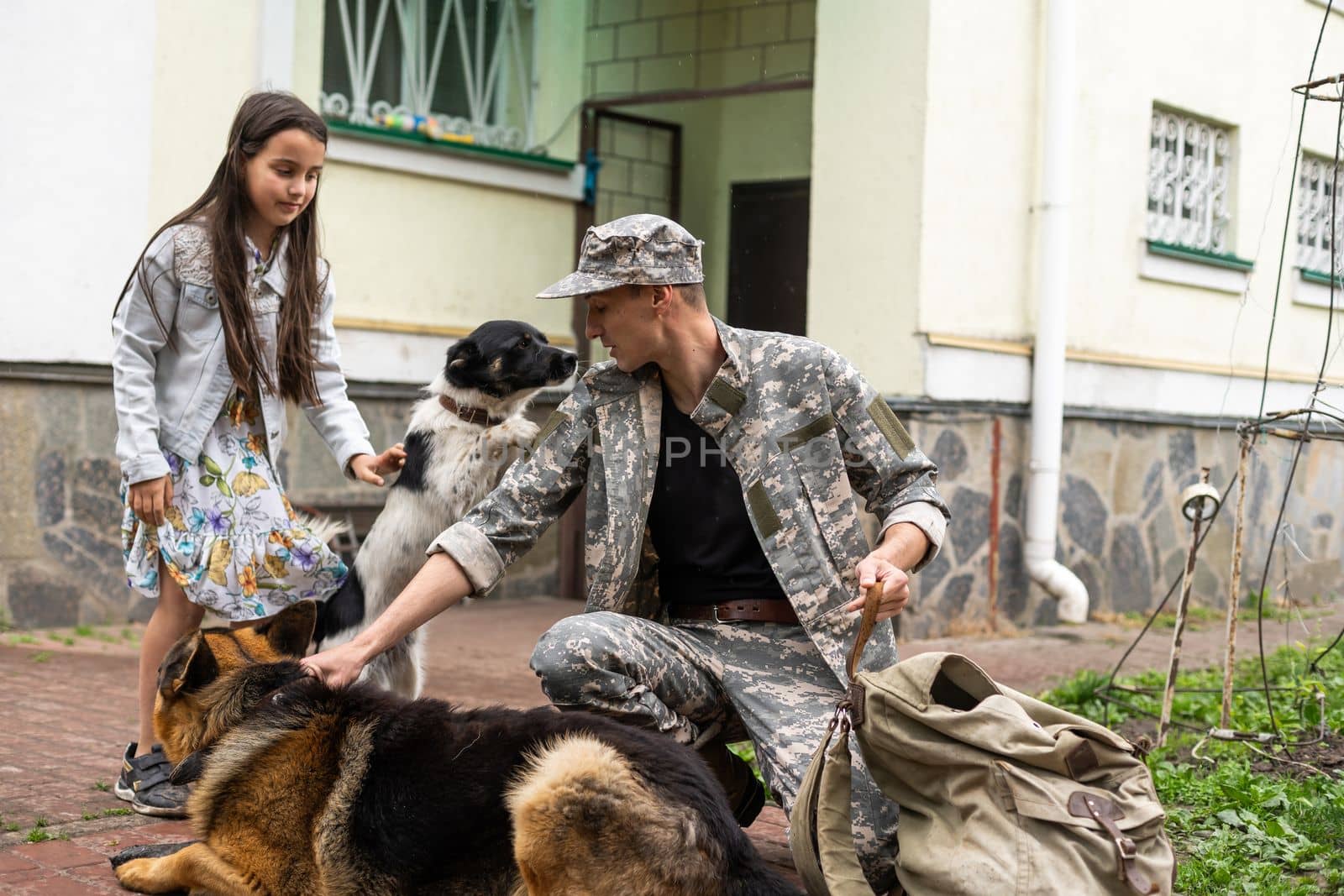 military father meeting with daughter and dogs.