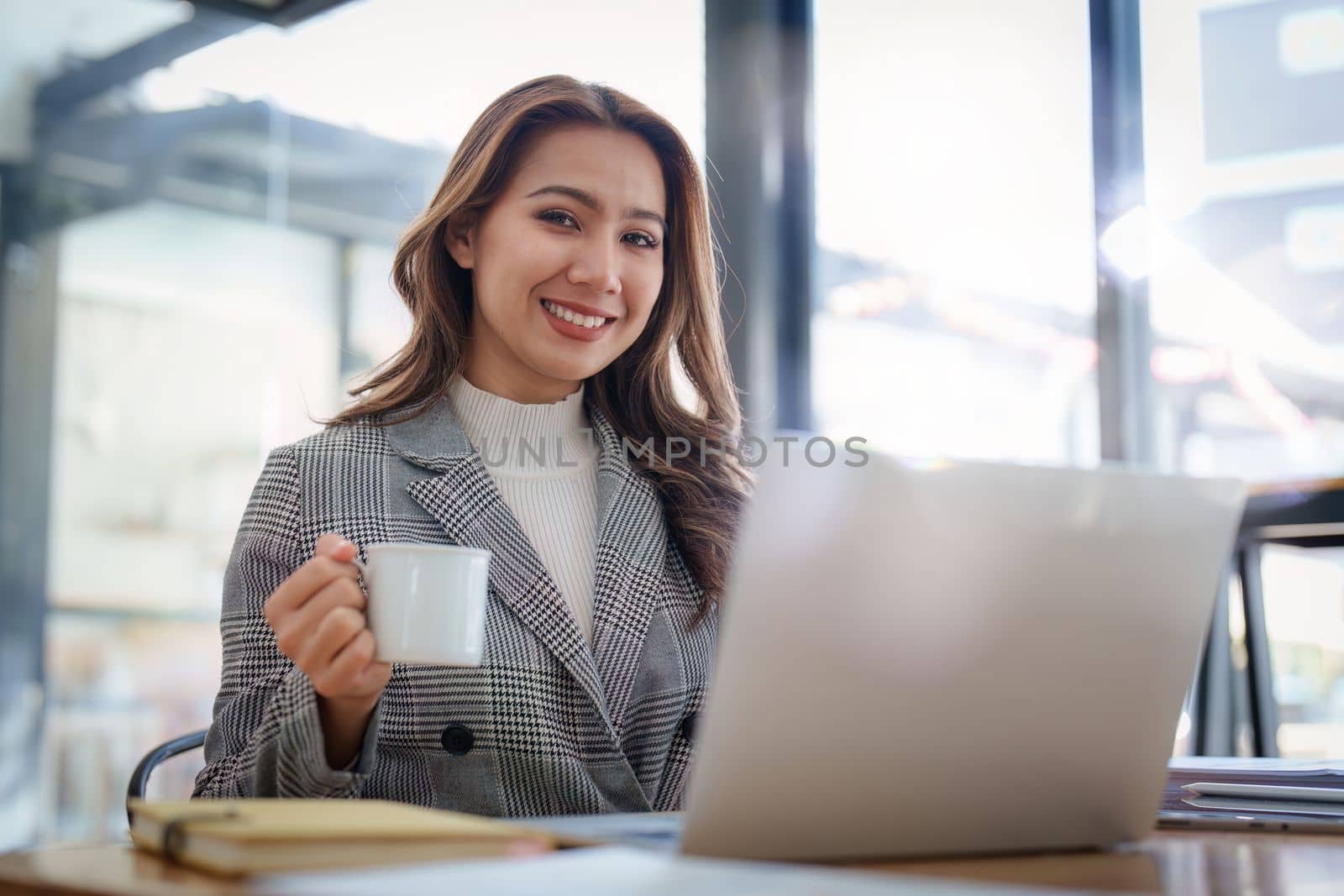 Portrait of Smiling asian business woman with laptop computer in office. Woman in suit at office.