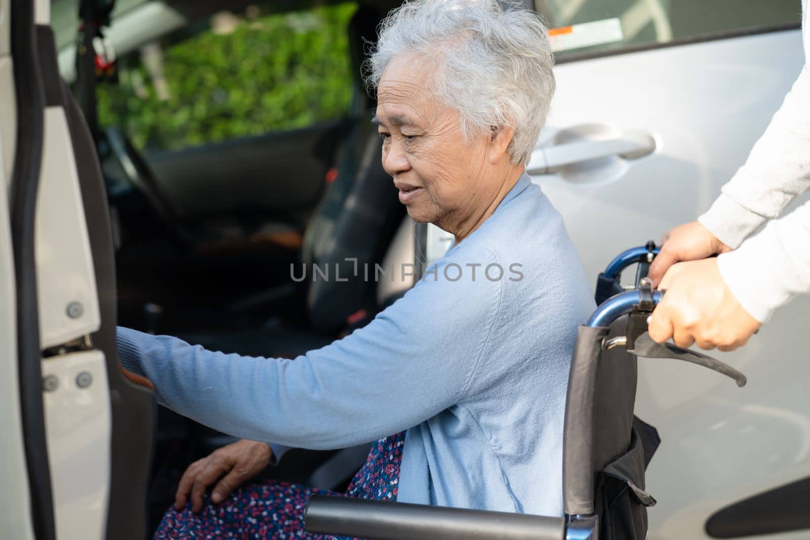 Asian senior or elderly old lady woman patient sitting on wheelchair prepare get to her car, healthy strong medical concept. by pamai