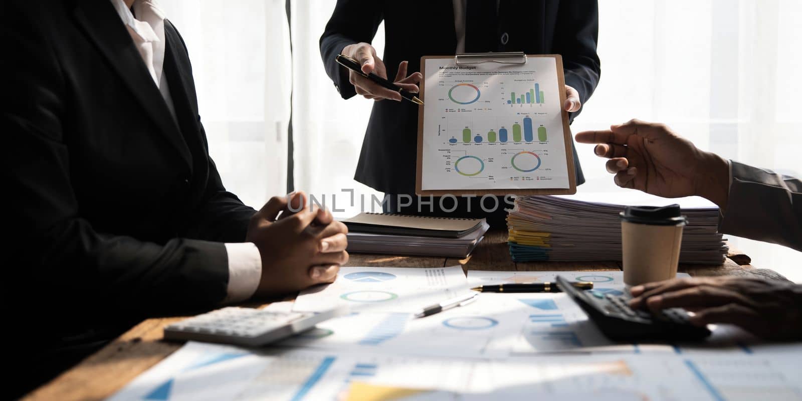 Business People Meeting using laptop computer,calculator,notebook,stock market chart paper for analysis Plans to improve quality next month. Conference Discussion Corporate Concept. by wichayada