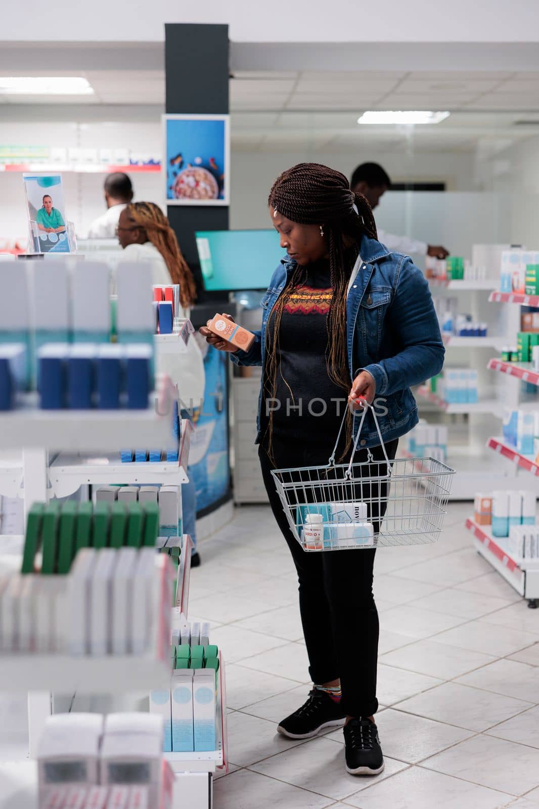 African american woman choosing sunscreen in pharmacy store by DCStudio