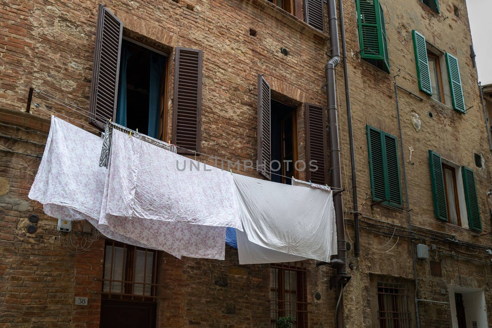 Laundry for drying is hung on the facade of an old building.