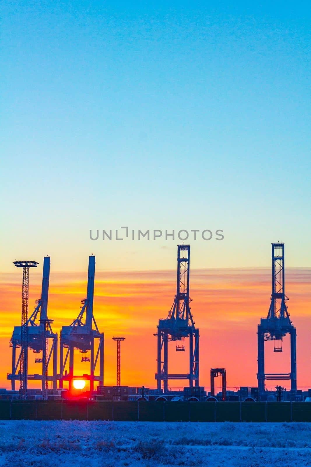 Shipyard cranes shipyard crane sunset winter container port Bremerhaven Germany. by Arkadij