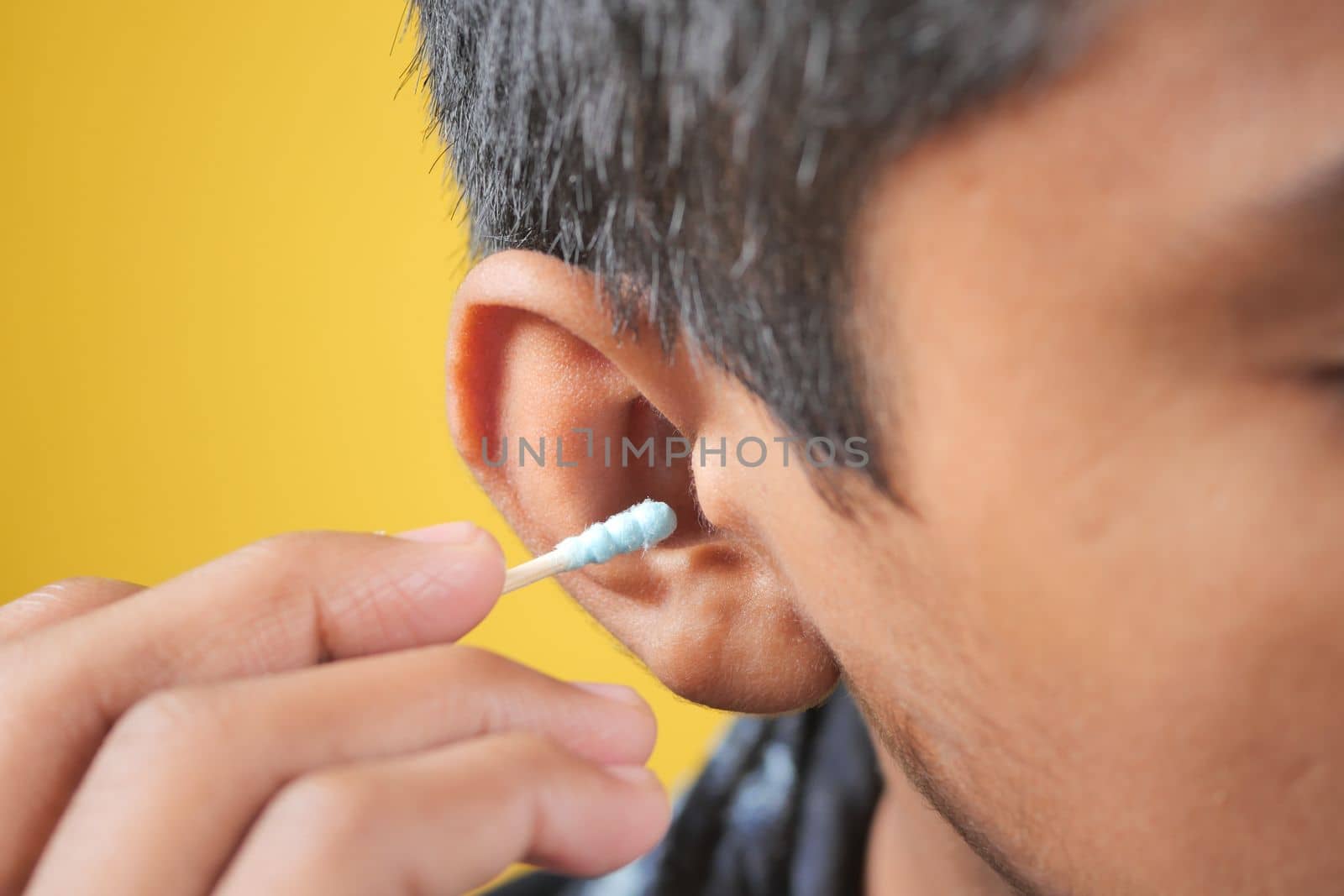 men using ear cotton bar close up .