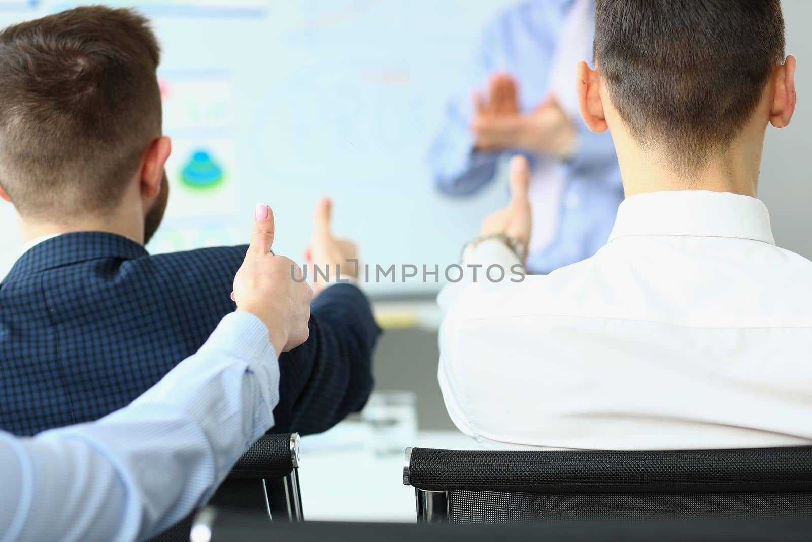 Team of business people hold thumbs up and recommend successful project. Partners present new project ideas successful business plan at the meeting.