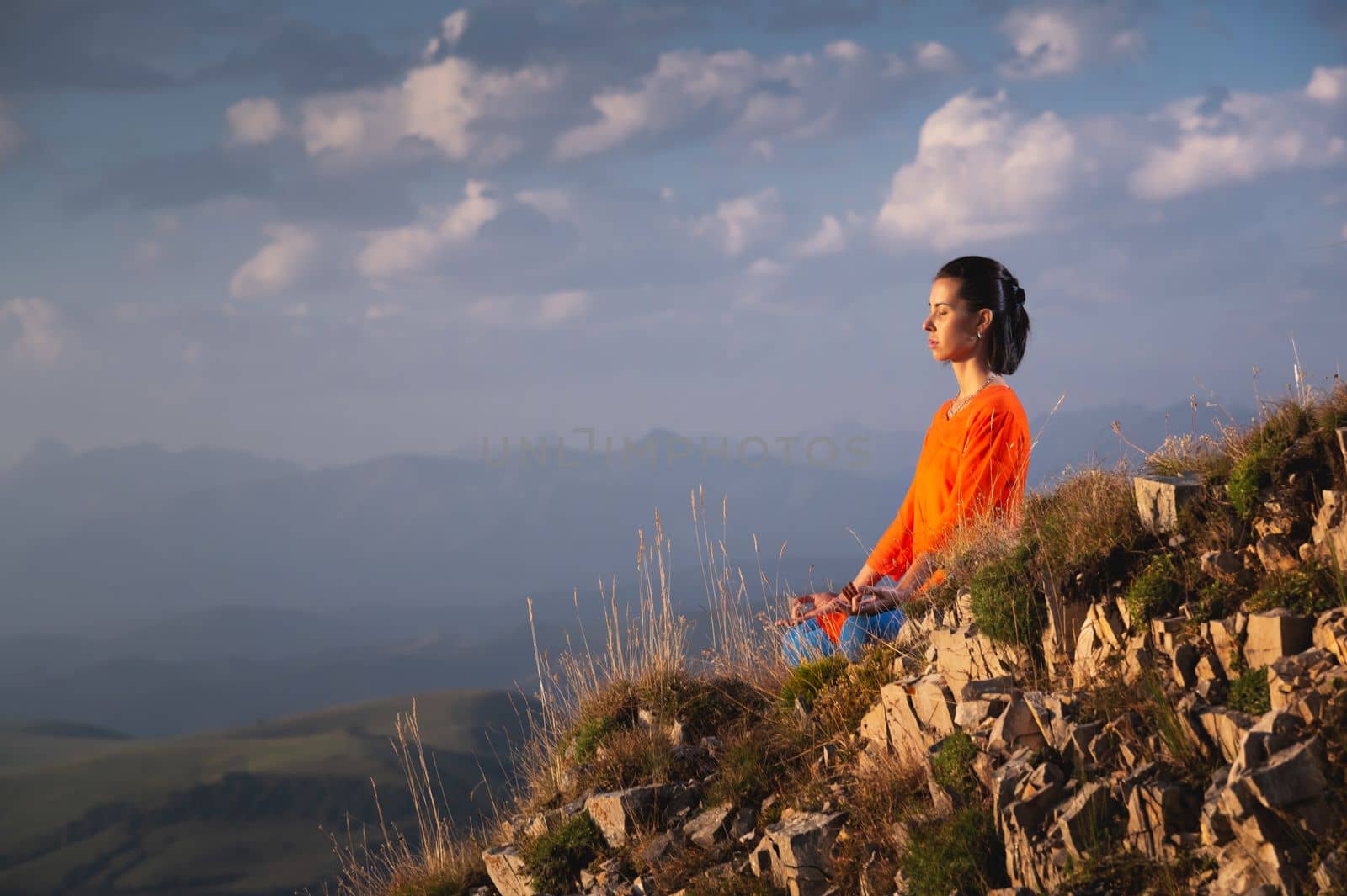 Serenity and yoga on a mountain range, meditation in the lotus position at dawn.